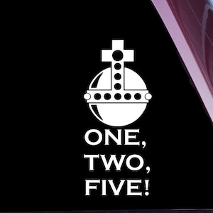 Peut inclure: Autocollant en vinyle blanc avec une image stylisée d'un globe avec une croix au sommet et le texte "ONE, TWO, FIVE!"