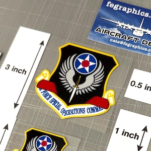 May include: A collection of Air Force Special Operations Command decals and stickers. The decals feature a shield design with a star and wing emblem, and the text "FORCE SPECIAL OPERATIONS COMMAND". Sizes range from 0.5 to 3 inches.