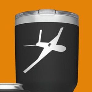 May include: A set of four Yeti tumblers with a silhouette of a plane on each. The tumblers are in black, blue, green, and silver. The tumblers are all different sizes. The tumblers are all labeled with the Yeti logo.