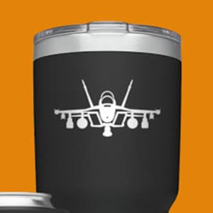 May include: Four different YETI tumblers with a white silhouette of a fighter jet on each. The tumblers are in black, green, white, and blue.