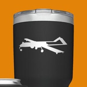 May include: A set of four Yeti tumblers with a silhouette of a drone on each. The tumblers are in black, blue, green, and silver. The tumblers are all the same size and shape. The Yeti logo is visible on each tumbler.