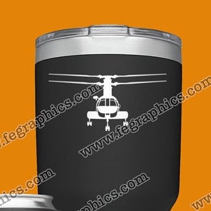 May include: Four different styles of tumblers with a helicopter graphic. The tumblers are black, green, blue, and silver. The helicopter graphic is white on the black tumbler, black on the green tumbler, white on the blue tumbler, and black on the silver tumbler. The tumblers are all on a orange background. The text "www.fegraphics.com" is on the tumblers. The text "Flight Engineered Graphics" is on the bottom of the black tumbler. The text "Aircraft Decals" is on the bottom of the black tumbler. The text "Veteran Owned Business" is on the bottom of the black tumbler. The text "Every Decal is Hand Made to order by me, NATE." is at the bottom of the image.
