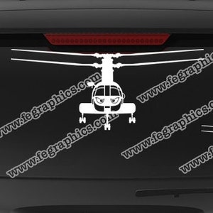 May include: A white decal of a helicopter on a black car window. The decal is a silhouette of a helicopter with a rotor on top. The decal is on the back window of a black car. The car is parked in front of a blue sky. The decal is from the company "fegraphics.com". The text "Flight Engineered Graphics" and "Veteran Owned Business" is also on the decal.