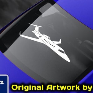 May include: A white decal of a private jet on a blue car. The decal is from Flight Engineered Graphics, a veteran-owned business. The text "Original Artwork by NATE" is visible on the image.