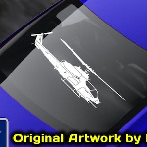 May include: A white silhouette of a helicopter on a blue car window. The text "www.fegraphics.com Flight Engineered Graphics Aircraft Decals VETERAN OWNED BUSINESS Original Artwork by NATE" is below the helicopter. The text "Every Decal is Hand Made to order by me, NATE." is at the bottom of the image.