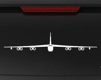 May include: A black SUV with a white silhouette of a B-52 bomber on the back window. The vehicle has a "Veteran Owned Business" sticker on the back.
