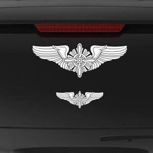 May include: A black SUV with a white Air Force veteran decal on the back window. The decal features a pair of wings with a propeller in the center. The text "Veteran Owned Business" is also on the back window.