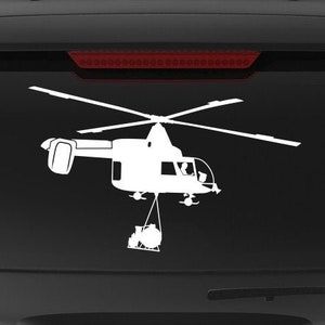 May include: A black SUV with a white silhouette of a helicopter on the back window. The helicopter is carrying a bucket. The SUV has a "Veteran Owned Business" sticker on the back.