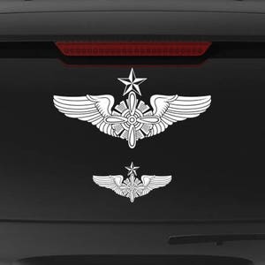 May include: A black SUV with a white Air Force wings and star decal on the back window. The decal is a symbol of the Air Force and is often used by veterans. The SUV also has a "Veteran Owned Business" sticker on the back.