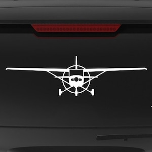 May include: A black SUV with a white silhouette of a small plane on the back window. The car has a "Veteran Owned Business" sticker on the back bumper.