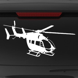 May include: A black SUV with a white silhouette of a helicopter on the back window. The vehicle has a "Veteran Owned Business" sticker on the back bumper.