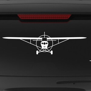 May include: A black SUV with a white silhouette of a small plane on the back window. The car has a "Veteran Owned Business" sticker on the back bumper.