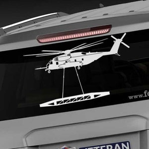 May include: A white silhouette of a helicopter with a cable and hook hanging down, on a gray car with a "Veteran Owned Business" sticker and the website "www.fegraphics.com" printed on the back.