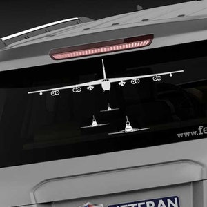 May include: A gray SUV with a white silhouette of a B-52 bomber on the back window. The vehicle has a "Veteran Owned Business" sticker with an American flag on the back. The text "www.fegraphics.com" is printed on the back of the vehicle.