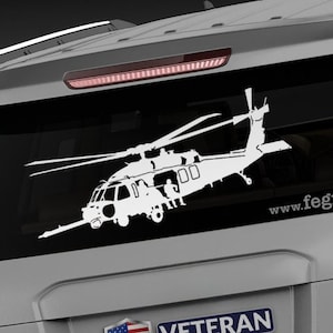 May include: A white silhouette of a helicopter on a gray vehicle with the text "Veteran Owned Business" and "www.fegraphics.com" on the back.