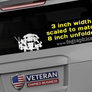 May include: A gray SUV with a black and white decal of a helicopter on the back window. The decal is 3 inches wide and scaled to match an 8 inch unfolded size. The text "3 inch width scaled to match 8 inch unfolded www.fegraphics.com" is in yellow on the decal. The text "www.fegraphics.com" is in black on the back of the SUV. A sticker with the text "Veteran Owned Business" and an American flag is on the back of the SUV.