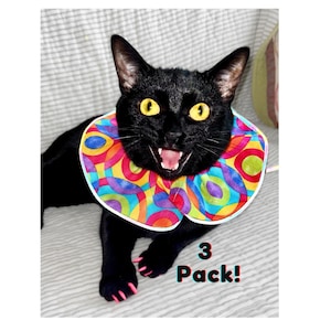 May include: Black cat with a colorful, circular patterned collar, wearing pink cat nail caps. The text "3 Pack!" is visible in the image.