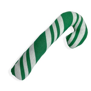Pode incluir: Uma almofada em forma de bengala de caramelo listrada de verde e branco. A almofada &eacute; feita de tecido e &eacute; uma decora&ccedil;&atilde;o divertida e festiva para as festas.