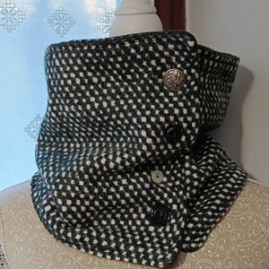 Peut inclure: Un tour de cou à carreaux noirs et blancs avec une teinte verte. Le tour de cou a une fermeture à bouton et un bouton décoratif.