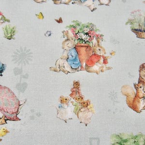 May include: A light blue fabric with a repeating pattern of Peter Rabbit characters. The characters include Peter Rabbit, Benjamin Bunny, and Mrs. Tiggy-Winkle. The fabric is perfect for quilting, sewing, and crafting.