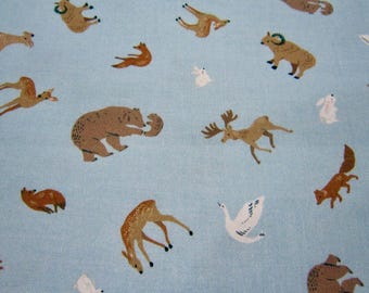 May include: A light blue fabric with a repeating pattern of various animals, including deer, bears, foxes, swans, and birds. The animals are brown, white, and black.