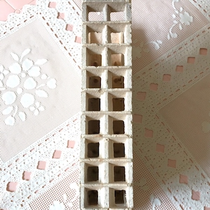 May include: White ceramic brick with a grid of square holes. The brick is about 10 inches tall and 3 inches wide.