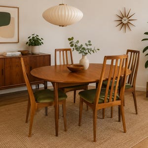 May include: A wooden dining set featuring an oval table and four chairs with vertical slat backrests and olive green upholstered seats. The furniture is crafted from medium-toned wood, complemented by a matching sideboard cabinet.