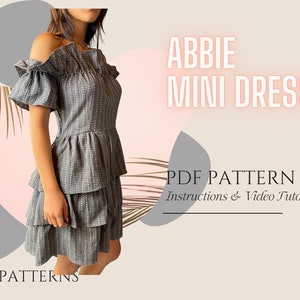 Op de afbeelding: Een grijze mini-jurk met wit patroon, off-shoulder-halslijn en gerimpelde zoom. De jurk heet "Abbie Mini Dress" en is een PDF-patroon met instructies en een video-tutorial.