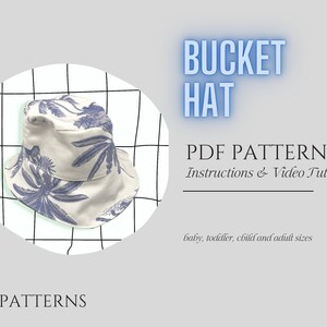 Op de afbeelding: Een witte bucket hat met een blauwe bloemenprint. De hoed is op een witte en zwarte rasterachtergrond. De tekst "BUCKET HAT" staat in blauwe letters boven de hoed. De tekst "PDF PATTERN" staat in zwarte letters onder de hoed. De tekst "Instructions & Video Tutorial" staat in zwarte letters onder de tekst "PDF PATTERN". De tekst "baby, toddler, child and adult sizes" staat in zwarte letters onder de tekst "Instructions & Video Tutorial".