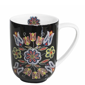 May include: Black ceramic mug with a white handle and interior. The mug features a colourful floral pattern in red, yellow, blue, and white. The floral design is repeated on the inside bottom of the mug.