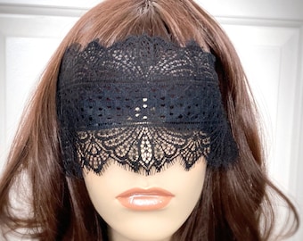 May include: Black lace eye mask with delicate floral patterns. The mask is worn on a mannequin with brown hair.