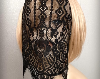 May include: Black lace face covering with a floral and geometric pattern. The lace is draped over a mannequin head with blonde hair. The text "Candied Cherry" is visible at the bottom right.