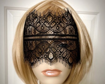May include: Black lace eye mask with a delicate scalloped edge. The mask covers the eyes and part of the forehead.