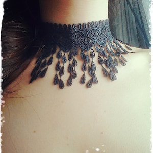 May include: A black lace choker necklace with a delicate fringe detail. The choker is made of a soft, lightweight material and has a delicate, feminine look.