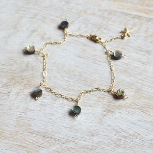 Könnte beinhalten: Ein goldenes Fußkettchen mit mehreren runden Perlmutt-Anhängern aus Abalone. Das Fußkettchen hat einen verstellbaren Verschluss.