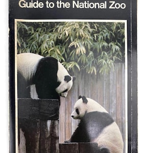 May include: A vintage book cover titled "Guide to the National Zoo" with a black border. The cover features a photograph of two giant pandas in a zoo setting. One panda is standing, and the other is sitting on a wooden structure.