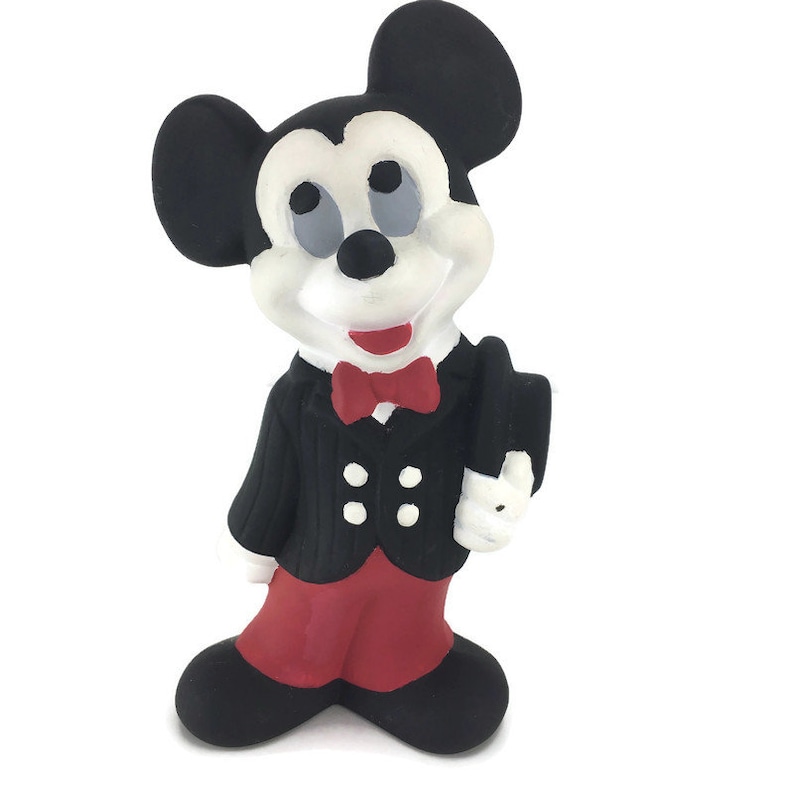 Op de afbeelding: Een zwart-witte keramische figuur van Mickey Mouse die een zwart pak met een rode broek en een rode strik draagt.