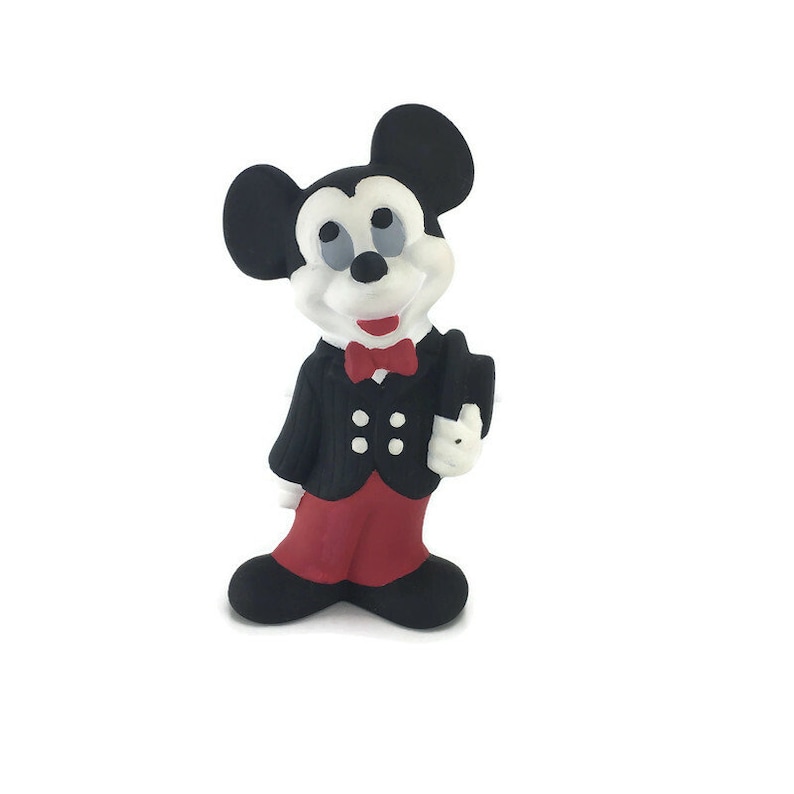 Op de afbeelding: Een zwart-witte keramische figuur van Mickey Mouse die een zwart pak met rode broek en een rode strik draagt.