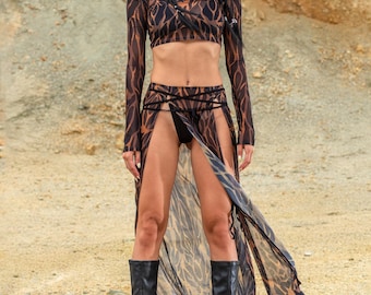 May include: A matching set of apparel with a brown and black animal print. The set includes a crop top, skirt, face covering, and head covering. The model is wearing black platform boots. The outfit is designed for a bold fashion statement.
