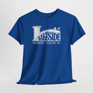 Op de afbeelding: Koningsblauw T-shirt met een witte afbeelding met de tekst "LAKESIDE" in een gestileerd lettertype, met daaronder "ROANOKE • SALEM, VA". Het shirt is gemaakt van zacht materiaal en heeft korte mouwen.