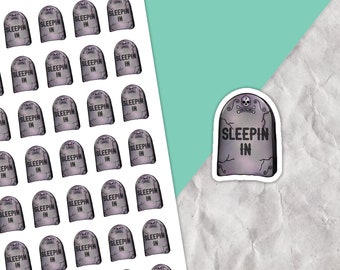 以下が含まれることがあります： 「Sleepin In」というテキストが書かれた墓石のデザインのステッカーシート。ステッカーはグリッドパターンで配置されており、プランナー、ラップトップ、ウォーターボトルにユーモアを加えるのに最適です。