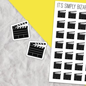 May include: A sheet of black and white clapperboard stickers. The stickers are approximately 1 inch in size and feature a simple design of a clapperboard.