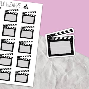 May include: A sheet of black and white clapperboard stickers. The stickers are arranged in a grid pattern. The clapperboards are a common symbol of filmmaking.