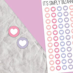 May include: A sheet of stickers featuring white hearts on a range of coloured circles. The circles are arranged in three rows of 10, with the colours graduating from peach to pink to purple. The text "IT'S SIMPLY BIZARRE" is at the top of the sheet.