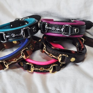 Puede incluir: Cinco pulseras de cuero con un diseño de bocado. Las pulseras son de diferentes colores, incluyendo turquesa, morado, azul, marrón y rosa.