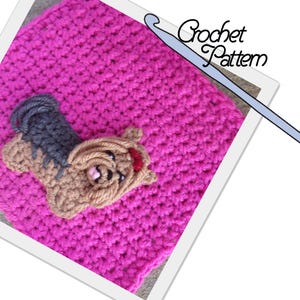 Puede incluir: Un patrón de crochet con un cuadrado rosa y una aplicación de Yorkshire Terrier de crochet marrón y gris. El texto "Crochet Pattern" es visible en la imagen.