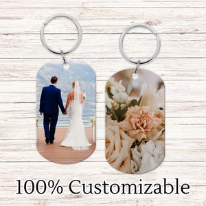 May include: Two personalized keychains with photo inserts. One keychain features a photo of a bride and groom walking away from the camera on a dock. The other keychain features a close-up of a bouquet of flowers.