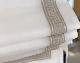 May include: White sheer roman shade with a beige trim featuring a Greek key pattern.