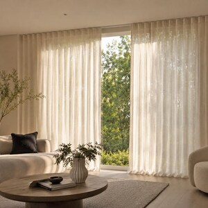 Modern living room with wall-to-wall sheer ripple fold curtains on a white ceiling mount aluminum track - soft daylight filtering through wave fold panels