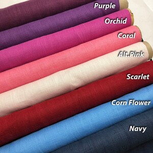 May include: A collection of eight fabric swatches rolled up and stacked on top of each other. The swatches are in the following order from top to bottom: Tuscany, Beet, Purple, Orchid, Coral, Alt.Pink, Scarlet, Corn Flower, Navy.
